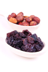 nuts and raisin are in a wooden spoon