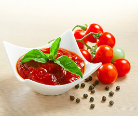 Red tomato sauce in a pan and ingredients