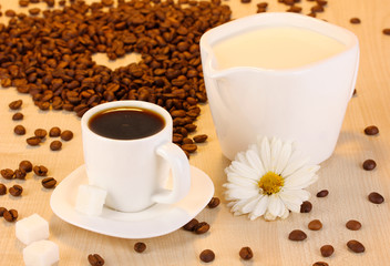 A cup of strong coffee and sweet cream on wooden table close-up