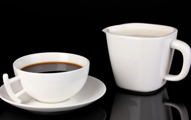A cup of strong coffee and sweet cream isolated on black
