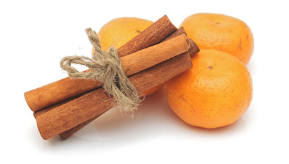 tangerines and cinnamon sticks on white background
