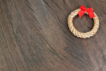 Straw Christmas wreath on a wooden texture.