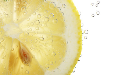 slice of lemon in the water with bubbles, isolated on white