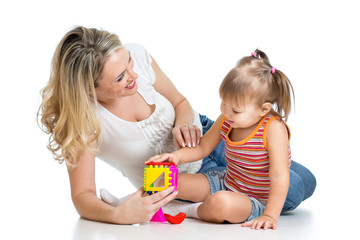 child girl and mother playing together with puzzle toy