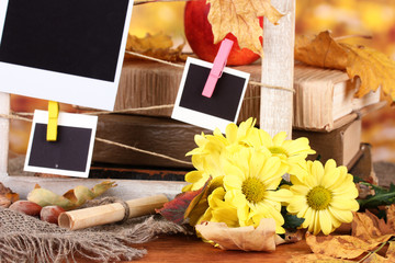 Autumnal composition with flowers, photo cards, wooden frame
