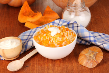Useful pumpkin porridge in white plate on wooden table close-up
