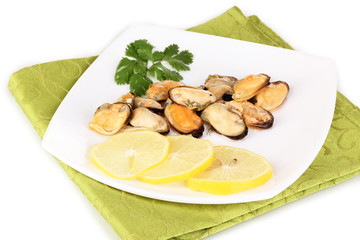 Snack of mussels and lemon on plate isolated on white
