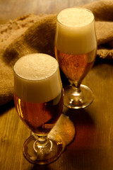 Glasses of beer on wooden table close-up