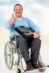 Friendly man in wheelchair holding thumbs up