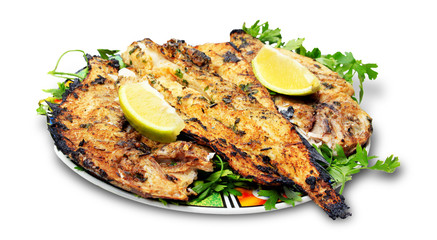 Grilled fish with greens on the plate - isolated on white backgr