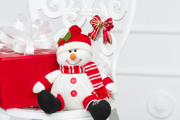 Smiling decorative snowman with red present box