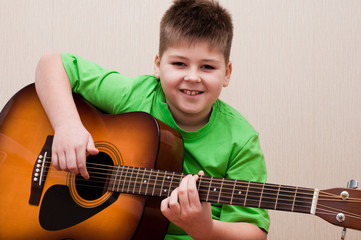 A boy learns to play the guitar