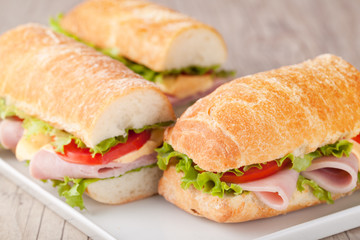 Sandwich with bacon and vegetables on wooden table