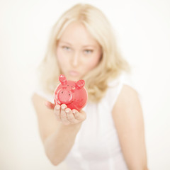 Attraktive junge Frau mit Sparschwein