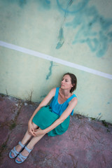 Fototapeta na wymiar assise contre un mur de tennis abandonné