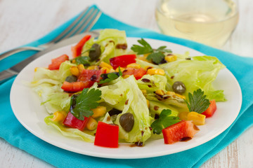salad on the white plate with glass of wine