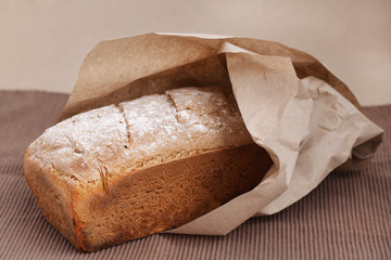 Loaf of bread made of corn flour wrapped in brown recycled paper
