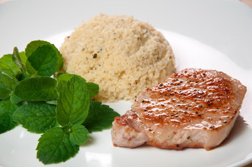 fried veal with couscous on the white plate