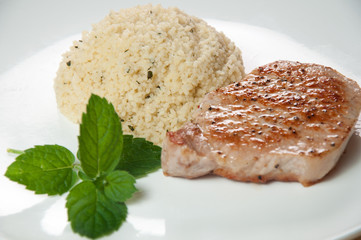 fried veal with couscous on the white plate
