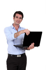 A businessman standing with his laptop.