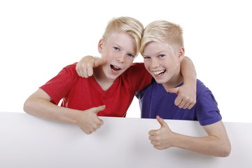 Zwei blonde Zwillinge Arm in Arm mit Daumen nach oben