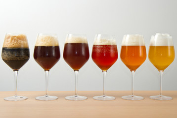 six glasses with different beers