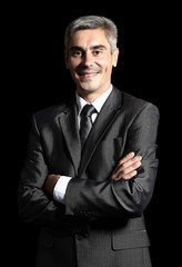 Closeup of a smiling senior man isolated over black background