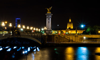 Obraz premium The Alexander III bridge and the dome of the Invalides at night