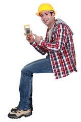 young handsome electrician pointing at tester