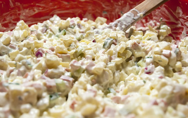 Closeup of a potato salad in red bowl