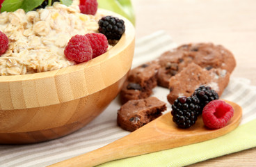 tasty oatmeal with berries, on wooden table
