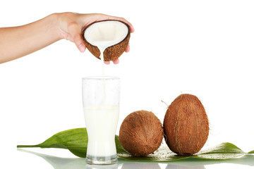 woman's hand pouring coconut milk into a glass