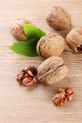 walnuts with green leaves, on wooden background