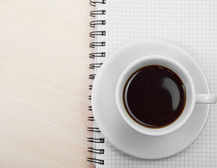 Coffee cup with note book on table