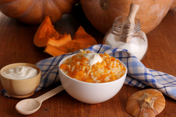 Useful pumpkin porridge in white plate on wooden table close-up