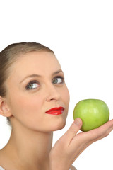 Woman in red lipstick holding a green apple