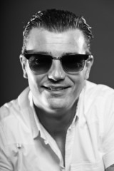 Obraz premium Macho man with short brown hair wearing sunglasses.