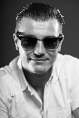 Obraz premium Macho man with short brown hair wearing sunglasses.