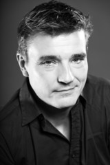 Obraz premium Handsome man with short brown hair. Black and white studio.