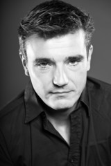 Fototapeta premium Handsome man with short brown hair. Black and white studio.