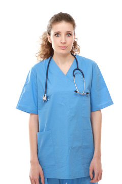Young nurse with stethoscope standing against