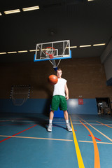 Fototapeta na wymiar Tough zdrowy młody mężczyzna gra w koszykówkę w siłownię.