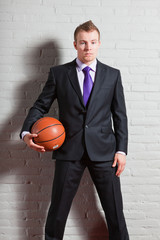 Business man with basketball. Gym indoor.
