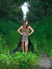 Girl in a black evening dress in the wood