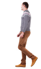 Back view of going   man in sweater and brown jeans.