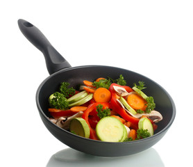 frying pan with vegetables on white