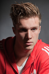 Obraz premium Fashion portrait of sportive young man wearing red jacket.