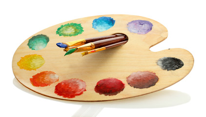 wooden art palette with paint and brushes isolated on white