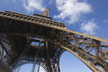 sunlit Eiffel Tower, Paris, against blue sky from below