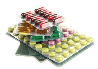 Capsules and pills packed in blisters, isolated on white
